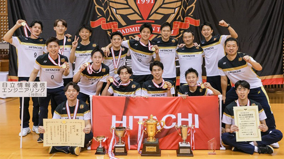 トロフィーと賞状の前で集合写真の写真